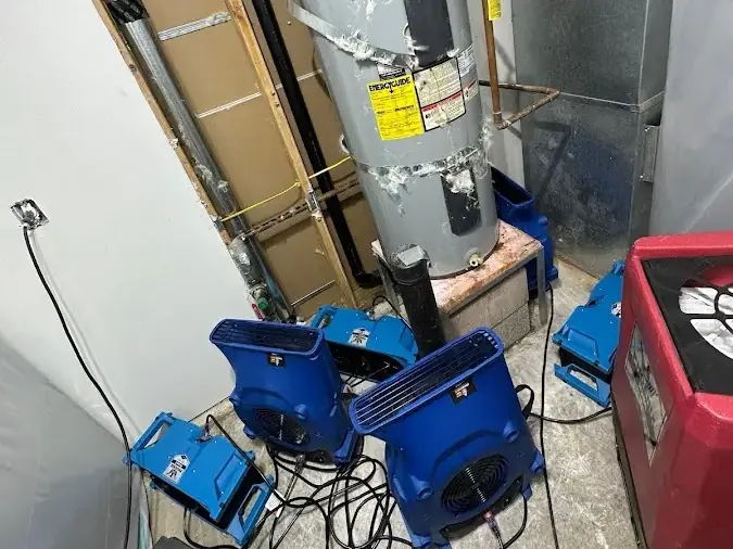 Air movers and a dehumidifier drying a water heater closet, representing Arlington jobs