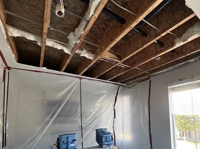 Ceiling opened to the joists with a dehumidifier running inside containment, Arlington example