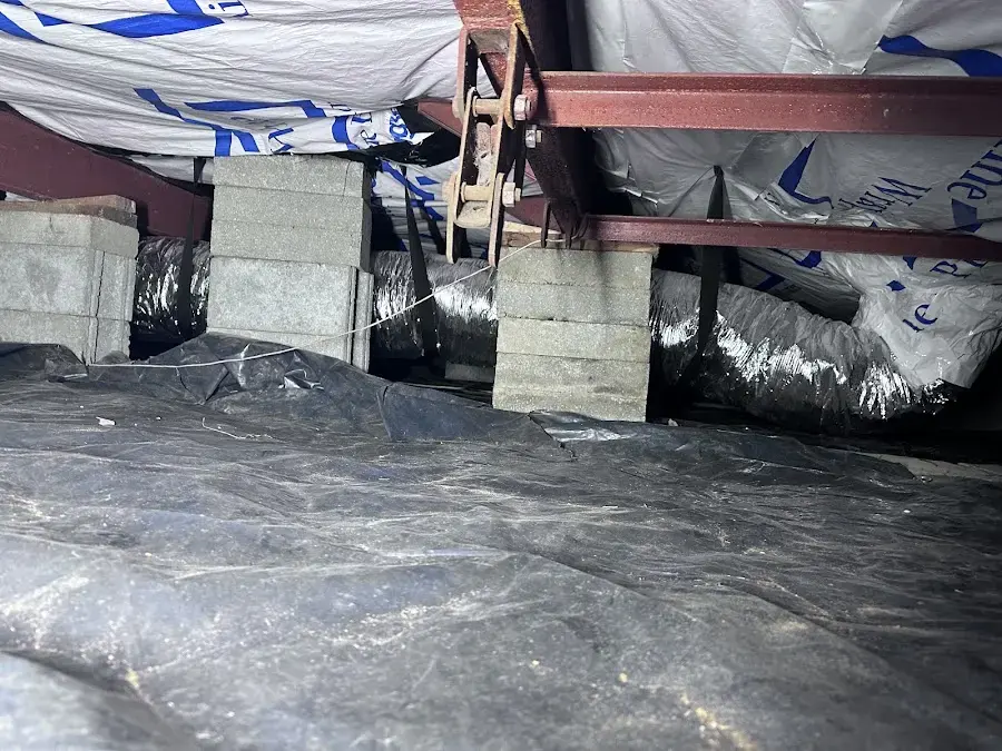 Plastic ground cover and ducting in a crawl space under a raised floor